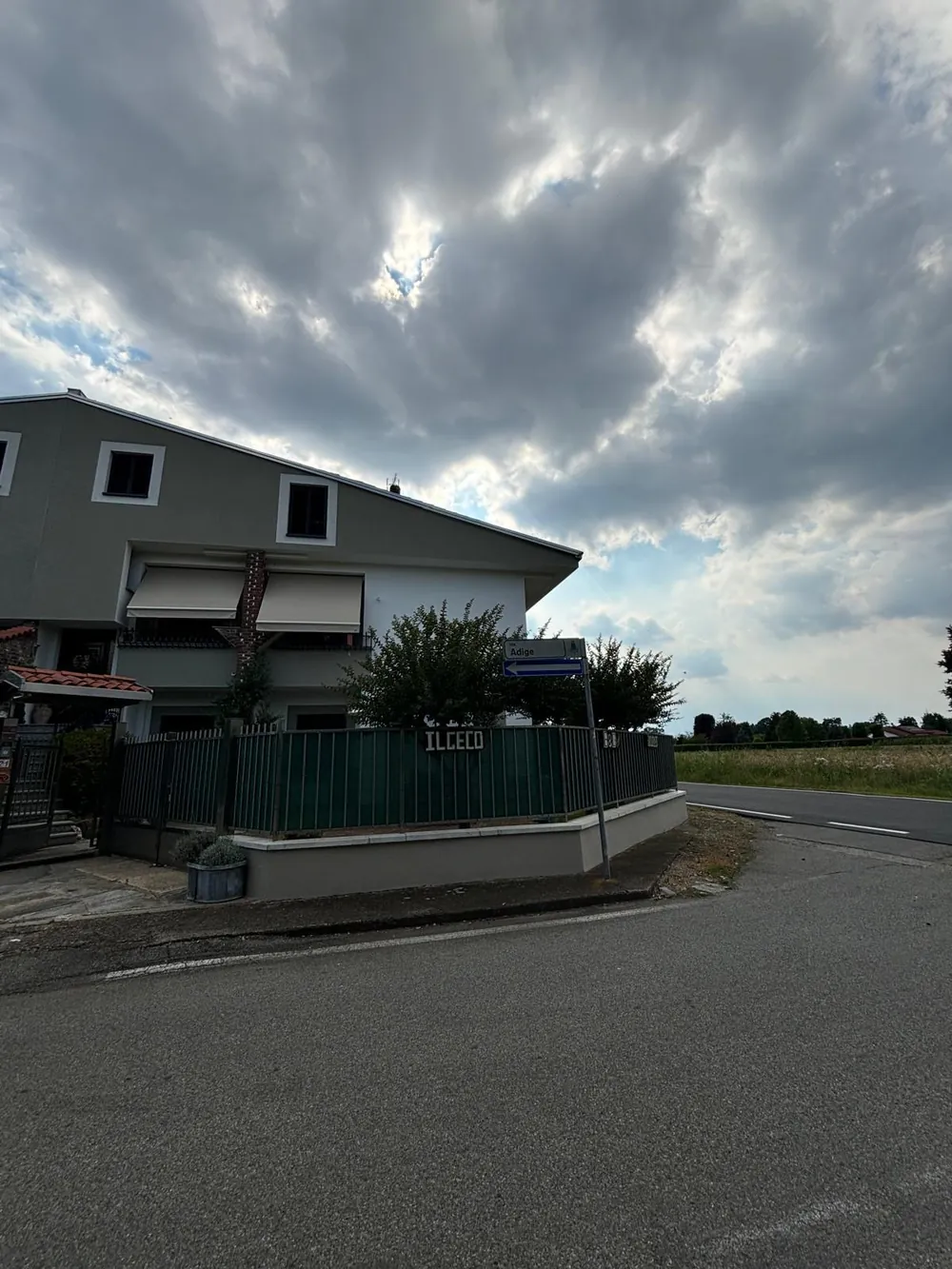 La facciata del B&B con la recinzione verde e l’insegna Il Geco, all’angolo di Via Adige